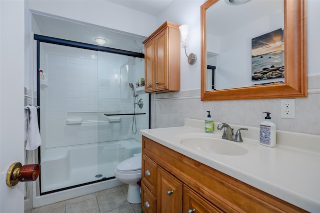 full bath featuring tile patterned floors, toilet, a stall shower, tile walls, and vanity