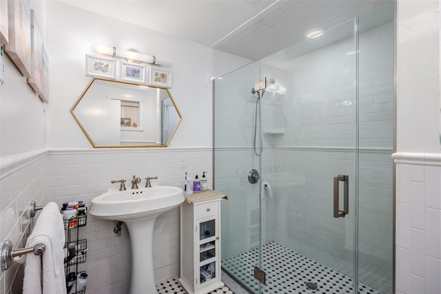 full bath with a shower stall, tile walls, and a wainscoted wall