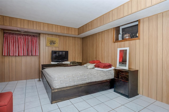 bedroom featuring wooden walls and light tile patterned floors