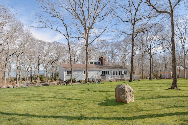 view of front of home with a chimney and a front lawn