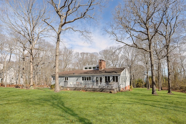 rear view of property with a lawn and a chimney