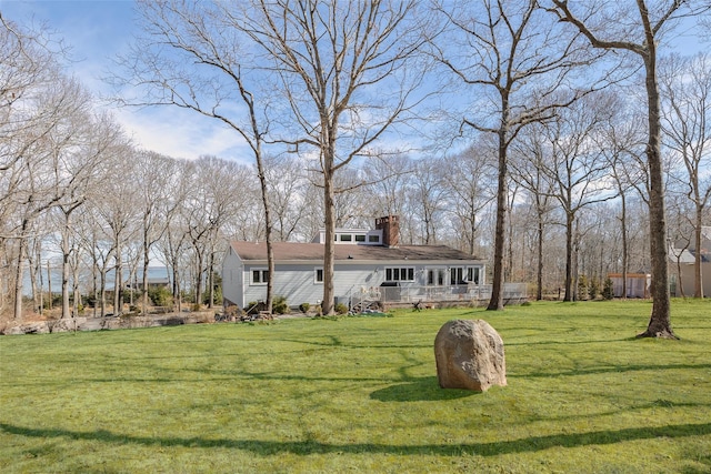 view of front facade with a chimney and a front lawn