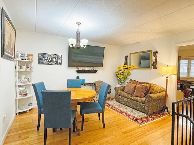 dining space featuring a notable chandelier, wood finished floors, and baseboards