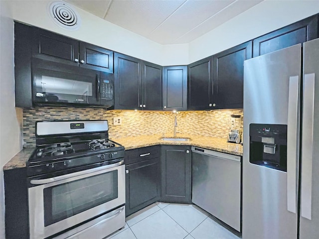 kitchen with light stone counters, visible vents, stainless steel appliances, and a sink