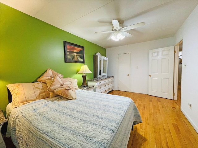 bedroom featuring a ceiling fan, light wood-type flooring, and baseboards