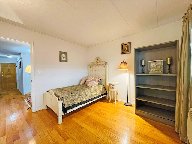 bedroom with baseboards and wood-type flooring