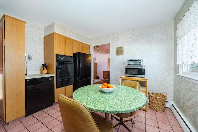 kitchen with black appliances, a warming drawer, light tile patterned floors, and baseboard heating