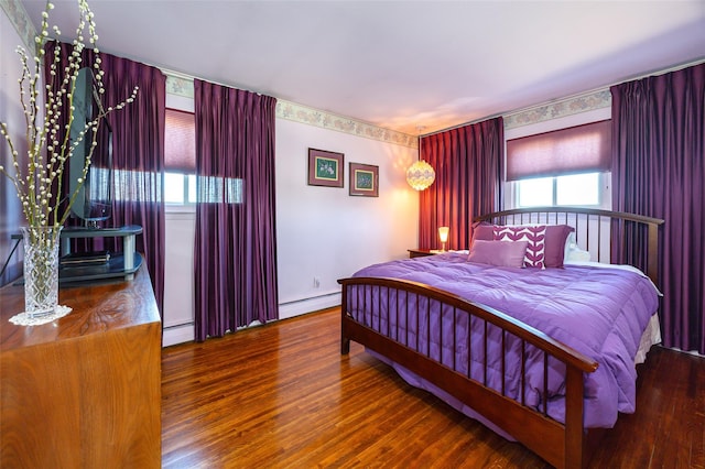 bedroom featuring a baseboard heating unit, baseboard heating, and wood finished floors