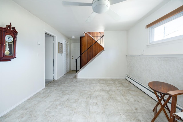 empty room with stairs, a ceiling fan, and baseboards