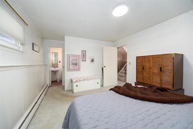 bedroom featuring a baseboard radiator, light carpet, and ensuite bath