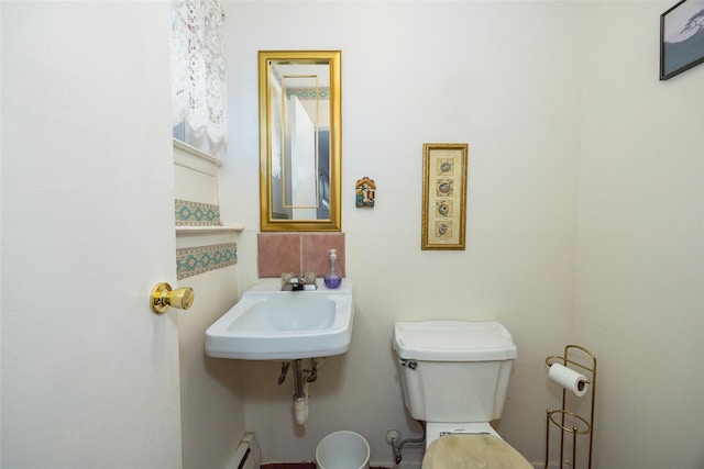 half bathroom featuring toilet, a baseboard heating unit, and a sink