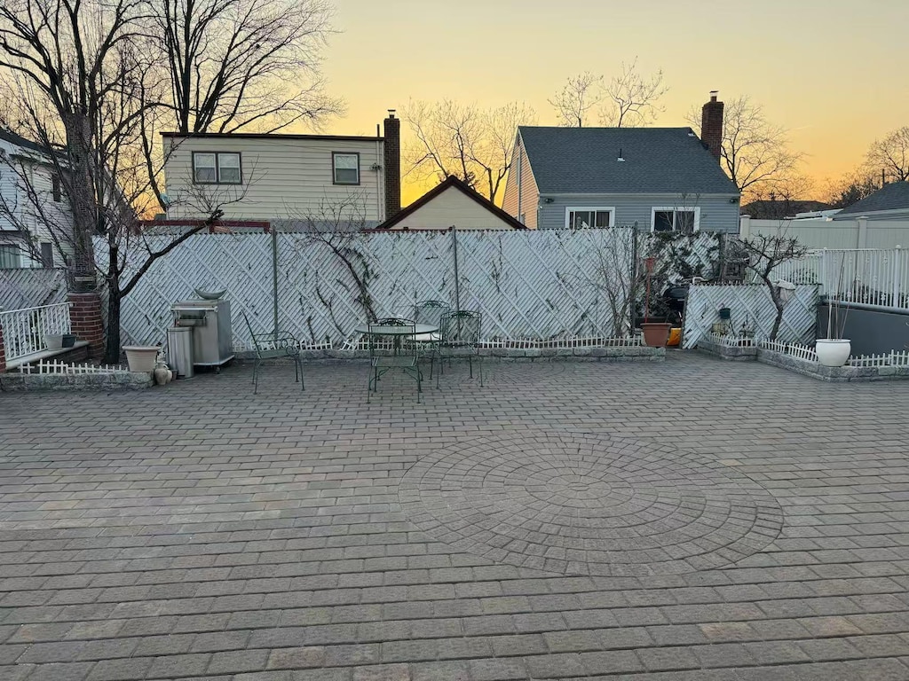 rear view of property with a patio, a chimney, and fence