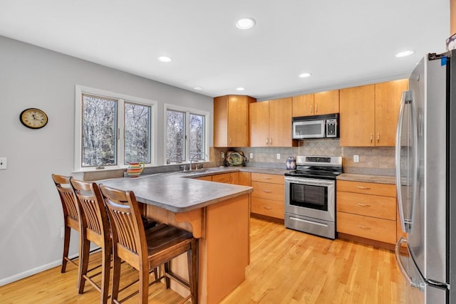 1380 Jackson Lndg, Mattituck, NY 11952 - kitchen featuring light wood-type flooring, stainless steel appliances, backsplash, and a peninsula