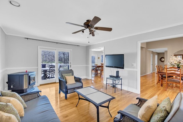 1380 Jackson Lndg, Mattituck, NY 11952 - living area with baseboards, ornamental molding, a wood stove, light wood-style floors, and a ceiling fan