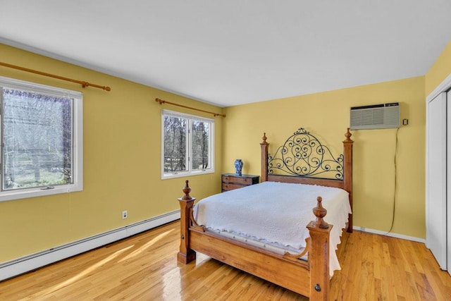 1380 Jackson Lndg, Mattituck, NY 11952 - bedroom featuring light wood finished floors, baseboard heating, a wall mounted air conditioner, and baseboards