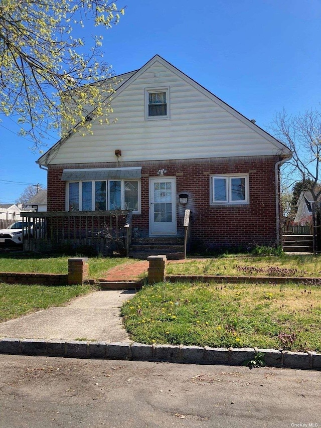 bungalow-style house with brick siding and a front yard