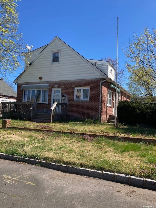 view of front of home with brick siding and a front yard