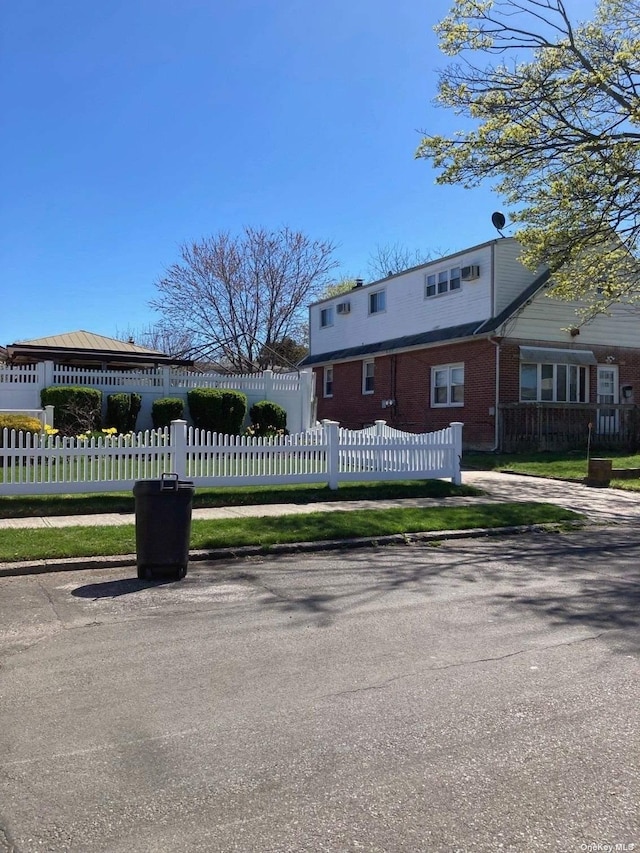 view of front of property with a fenced front yard and brick siding