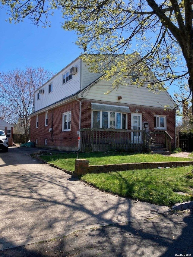 view of front of house featuring brick siding and a front yard