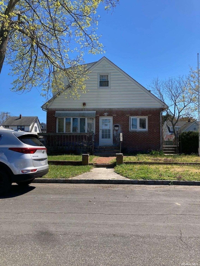 view of front of property featuring a front lawn and brick siding