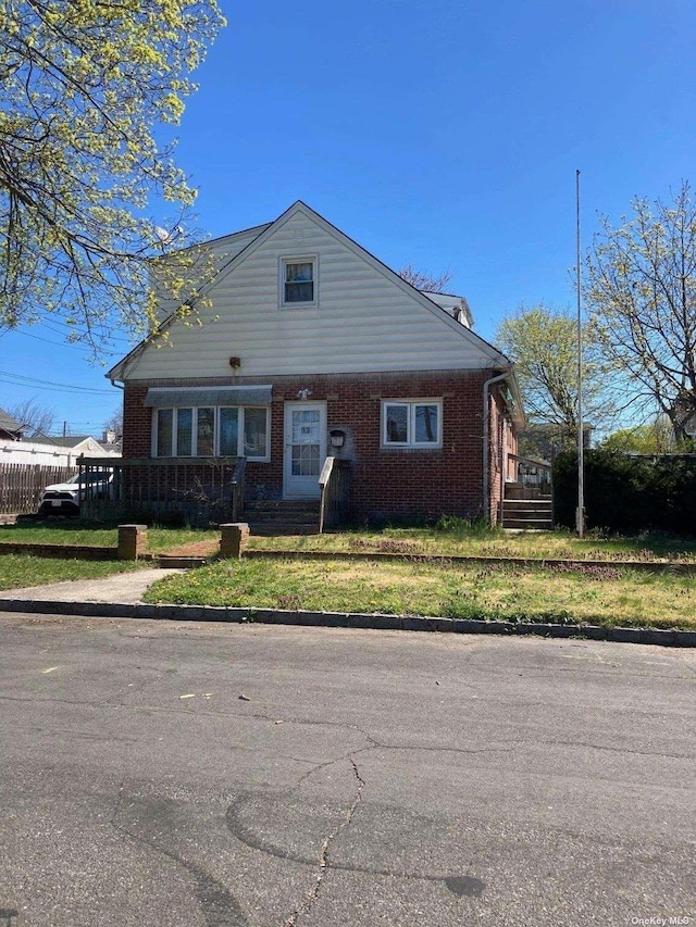 view of front facade featuring brick siding and a front lawn