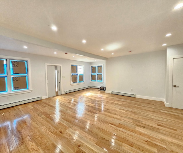 unfurnished living room featuring recessed lighting, light wood-style floors, and a baseboard radiator