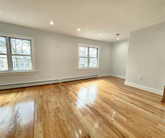 spare room featuring recessed lighting, baseboards, light wood-style floors, and a baseboard radiator