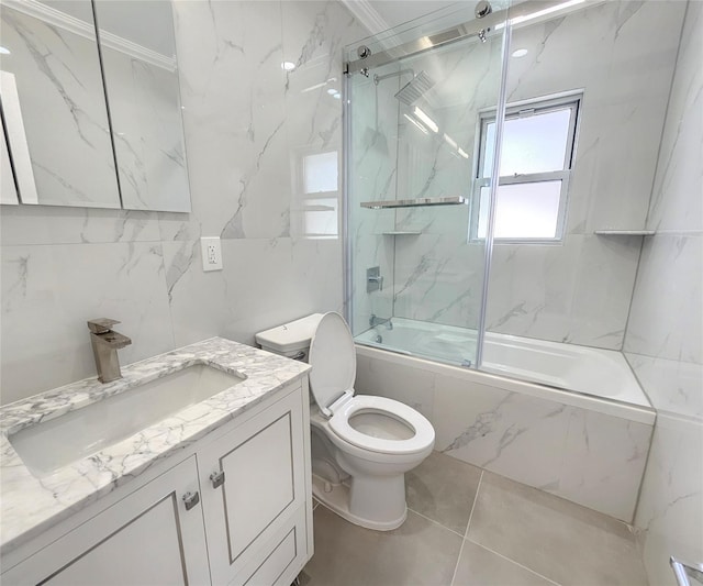 full bathroom featuring toilet, combined bath / shower with glass door, tile walls, crown molding, and vanity