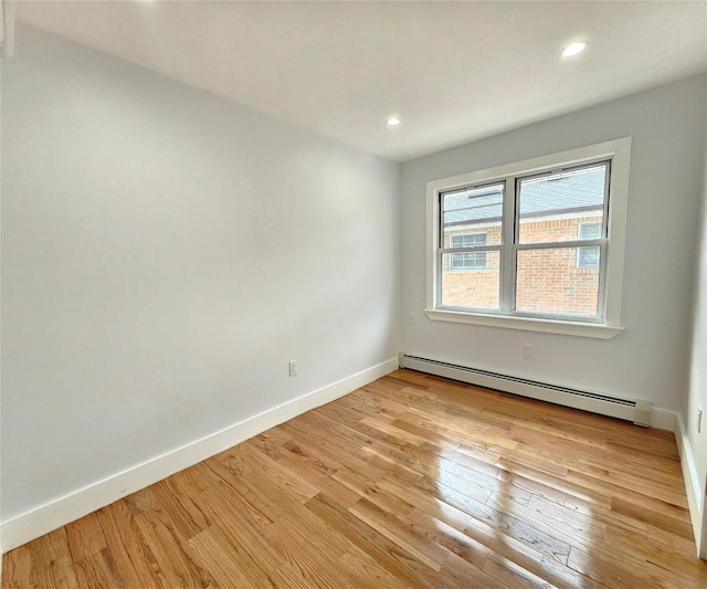 spare room with baseboard heating, recessed lighting, baseboards, and light wood-style floors