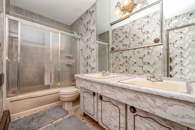 full bathroom featuring tile patterned floors, bath / shower combo with glass door, toilet, and a sink