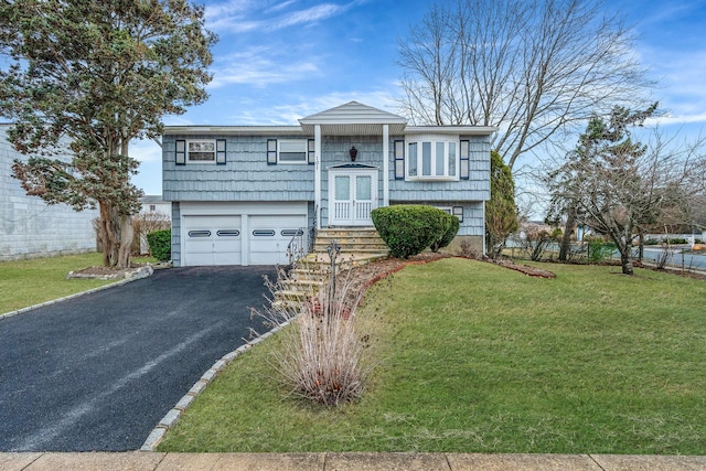 split foyer home with driveway, an attached garage, and a front lawn