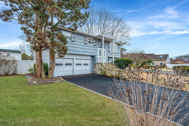 view of front of home featuring aphalt driveway, a front yard, an attached garage, and fence