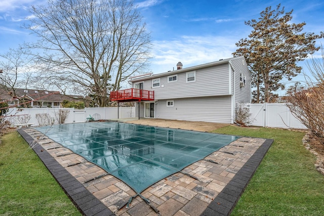 view of pool featuring a gate, a fenced backyard, a yard, a wooden deck, and a patio area