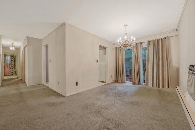 carpeted spare room with a notable chandelier, a baseboard heating unit, and ornamental molding