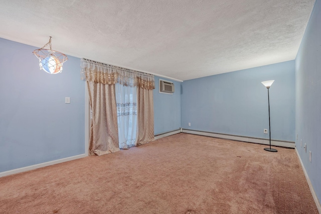 spare room featuring carpet flooring, a textured ceiling, a wall mounted air conditioner, and baseboards