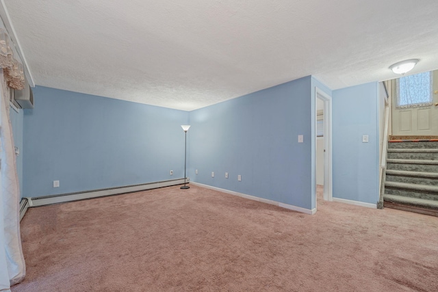 unfurnished room featuring baseboard heating, stairway, a textured ceiling, and carpet floors