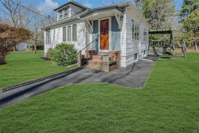 view of front of property with driveway, a front yard, and entry steps