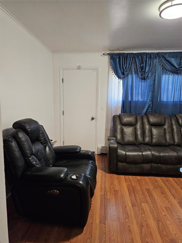 living room featuring wood finished floors, baseboard heating, and ornamental molding