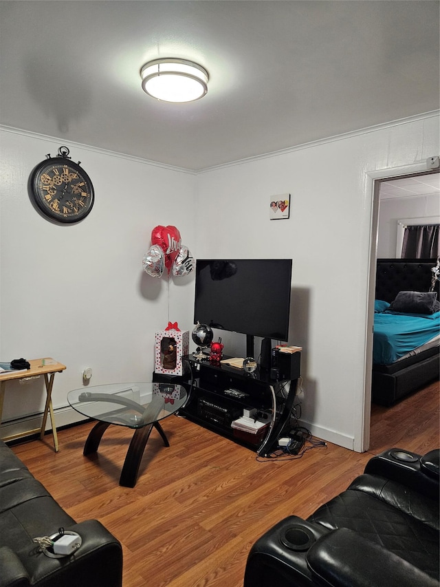 living area with baseboards, wood finished floors, and crown molding
