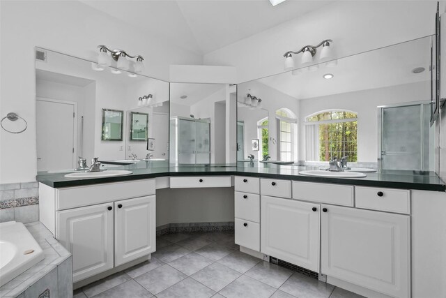 bathroom featuring vaulted ceiling, tile patterned flooring, a shower stall, two vanities, and a bath