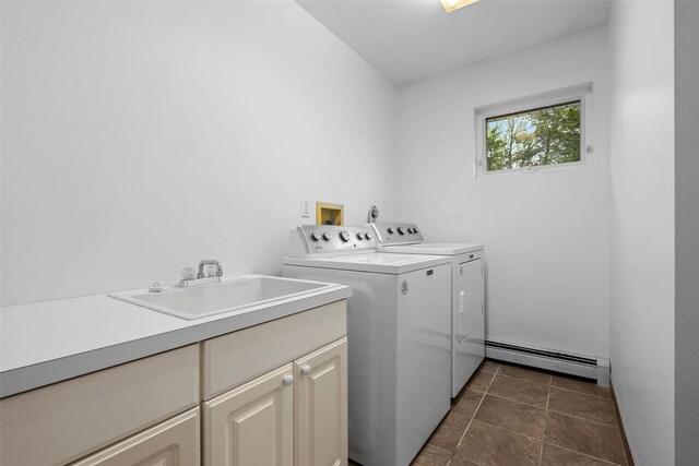 laundry room with a baseboard heating unit, cabinet space, and separate washer and dryer