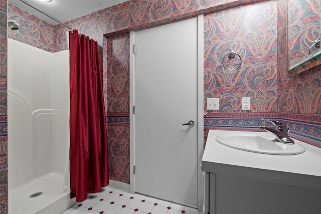 full bath with wallpapered walls, a shower stall, tile patterned floors, and vanity
