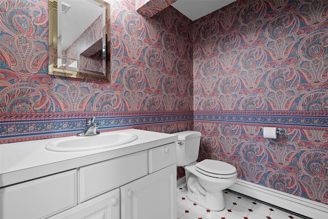 bathroom with wallpapered walls, a baseboard heating unit, toilet, vanity, and tile patterned floors