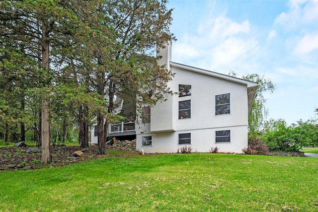 back of property featuring stucco siding and a lawn