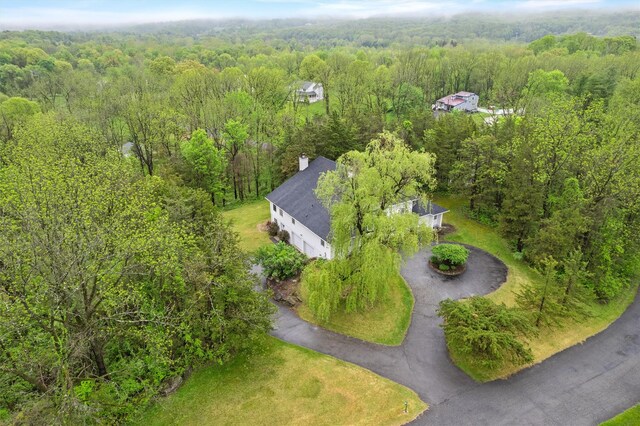 aerial view of property and surrounding area with a heavily wooded area