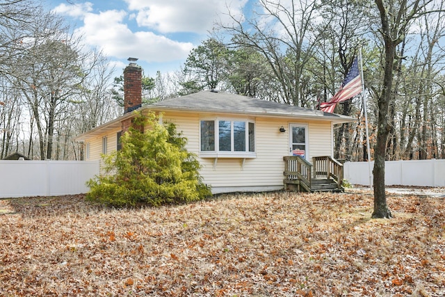 view of front of house with fence and a chimney