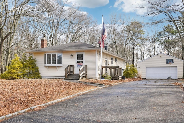 view of front of house with an outdoor structure, a garage, and a chimney