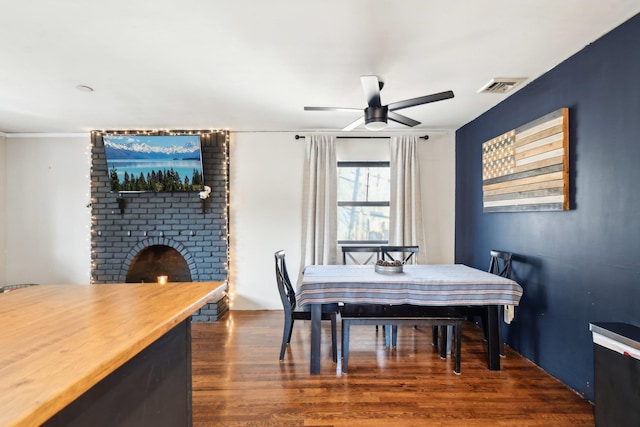 dining area with visible vents, dark wood finished floors, and a ceiling fan