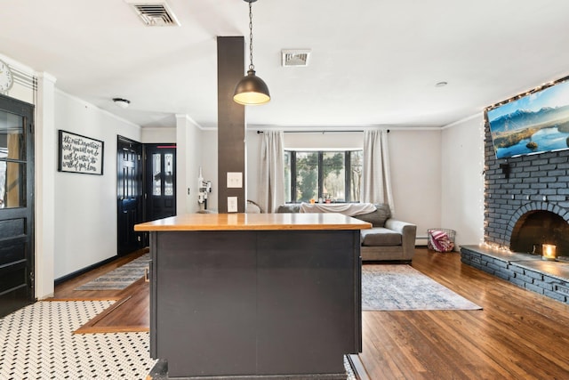 kitchen with visible vents, wooden counters, crown molding, open floor plan, and dark wood-style flooring