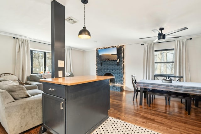 kitchen featuring visible vents, open floor plan, dark wood-style floors, a fireplace, and butcher block counters